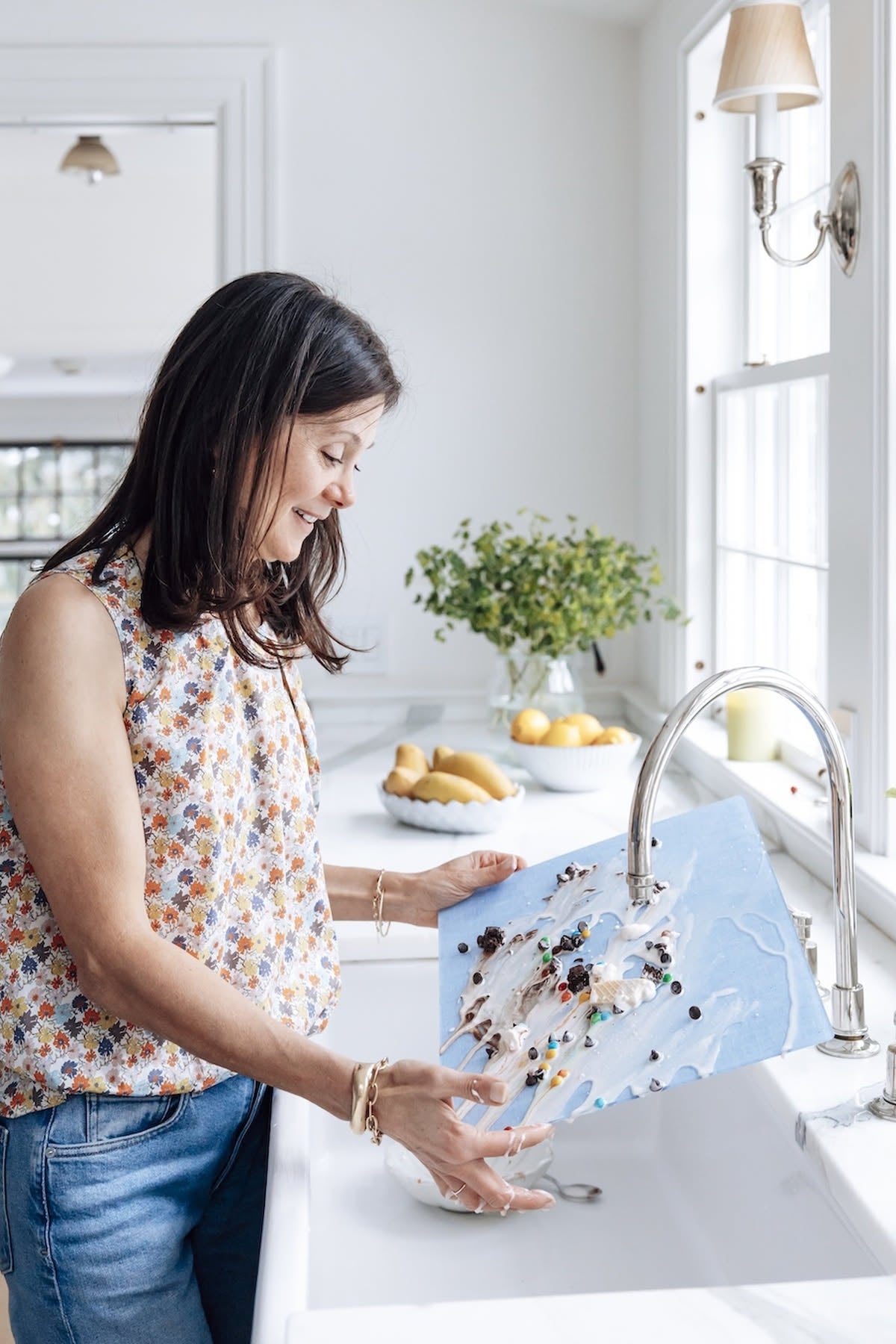 
                  
                    Proper Table founder rinsing a Campbell blue chambray acrylic placemat at the kitchen sink, a wipeable placemat that cleans in seconds
                  
                