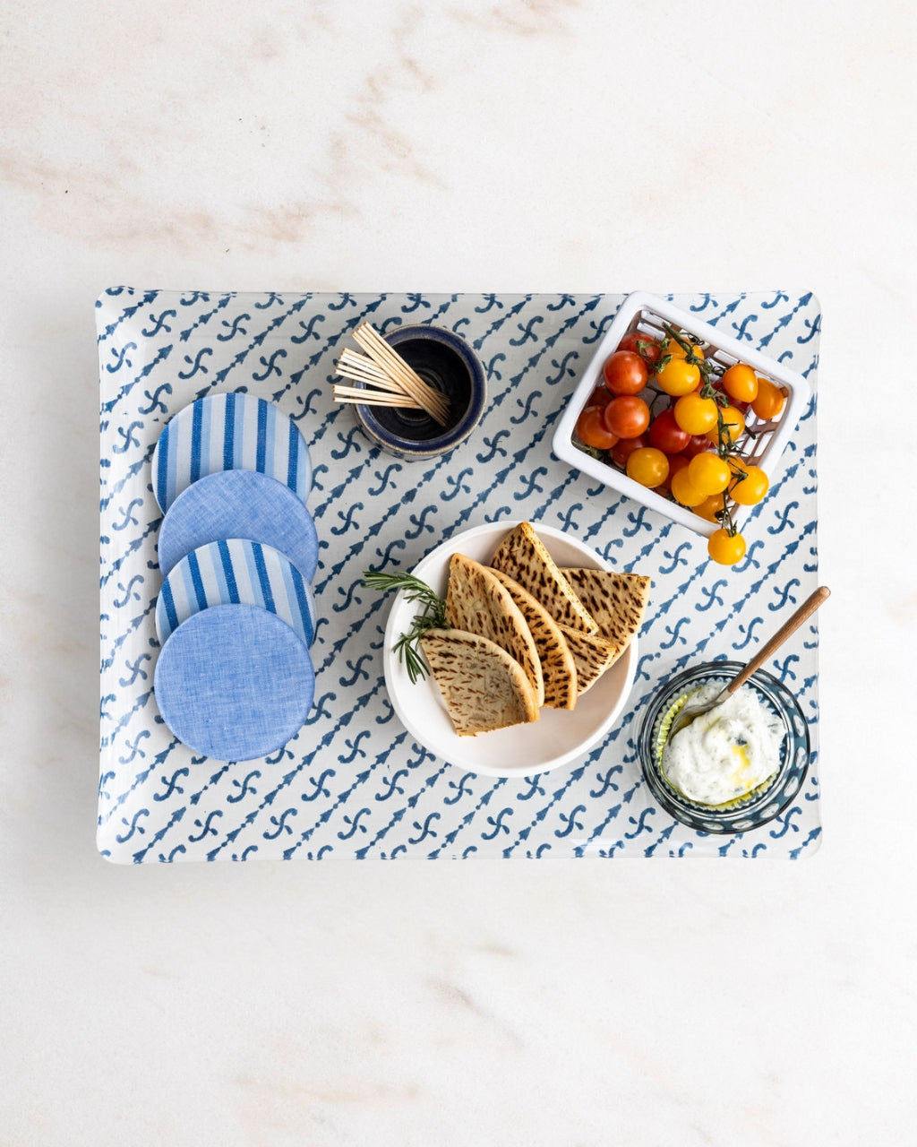 Acrylic block print tray with Campbell Blue Chambray coasters and mediterrean snacks.