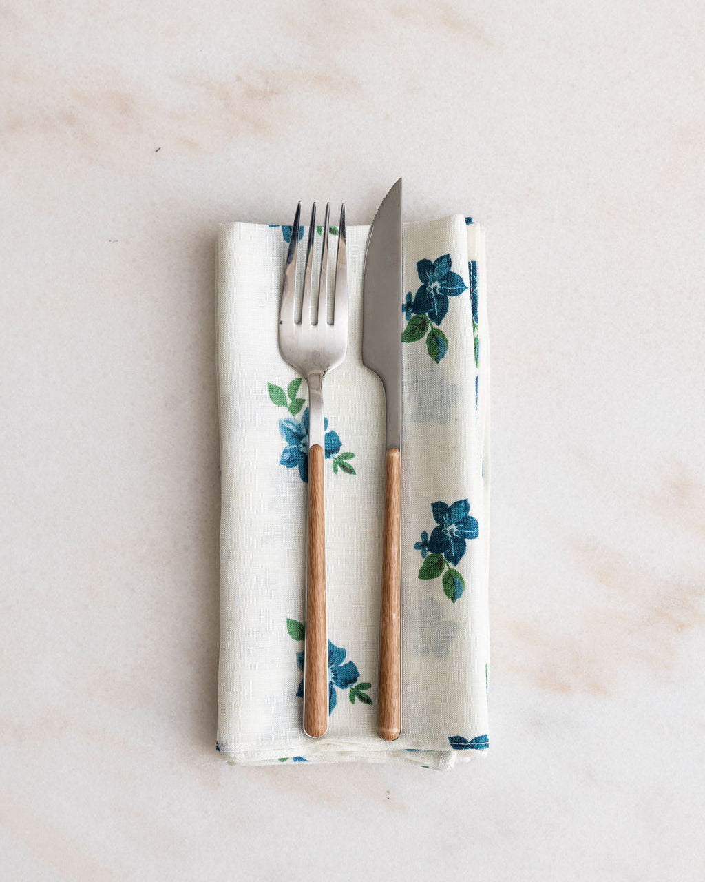 Nathan Turner Floral-patterned Anna napkin with fork and knife on a light background
