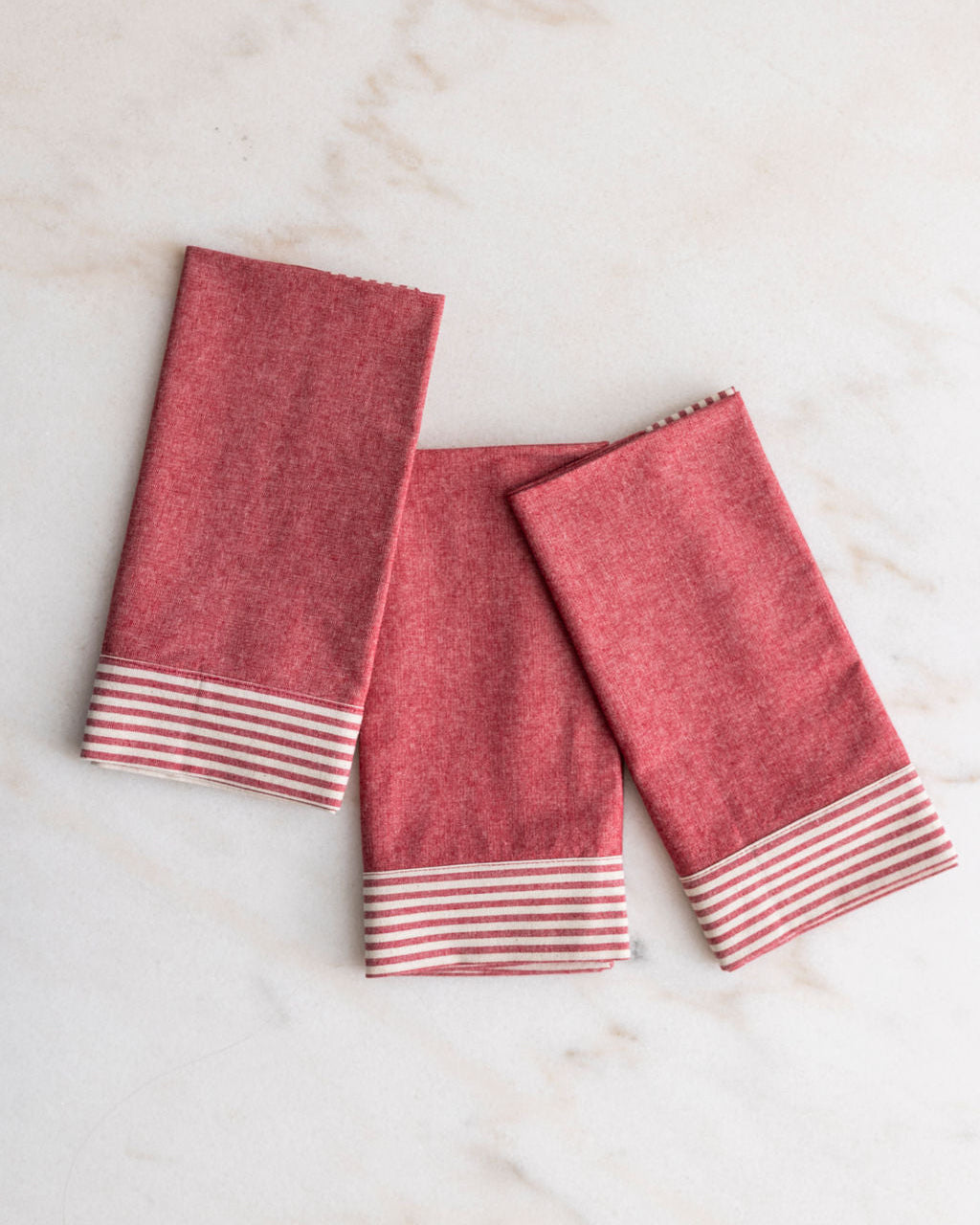 Phineas pink and white striped napkins on a marble surface