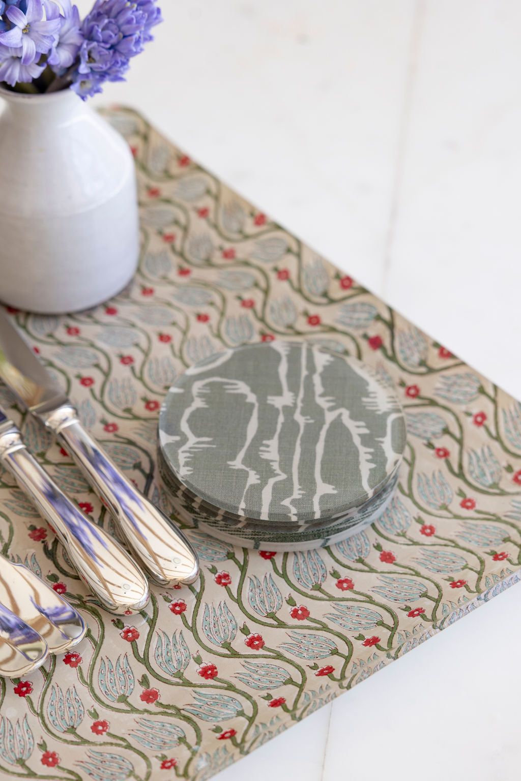 
                  
                    Close-up of the Adelaide tray in Verdant with a stack of gray marbled acrylic coasters and a bud vase, a wipe-clean tray and coaster gift set
                  
                