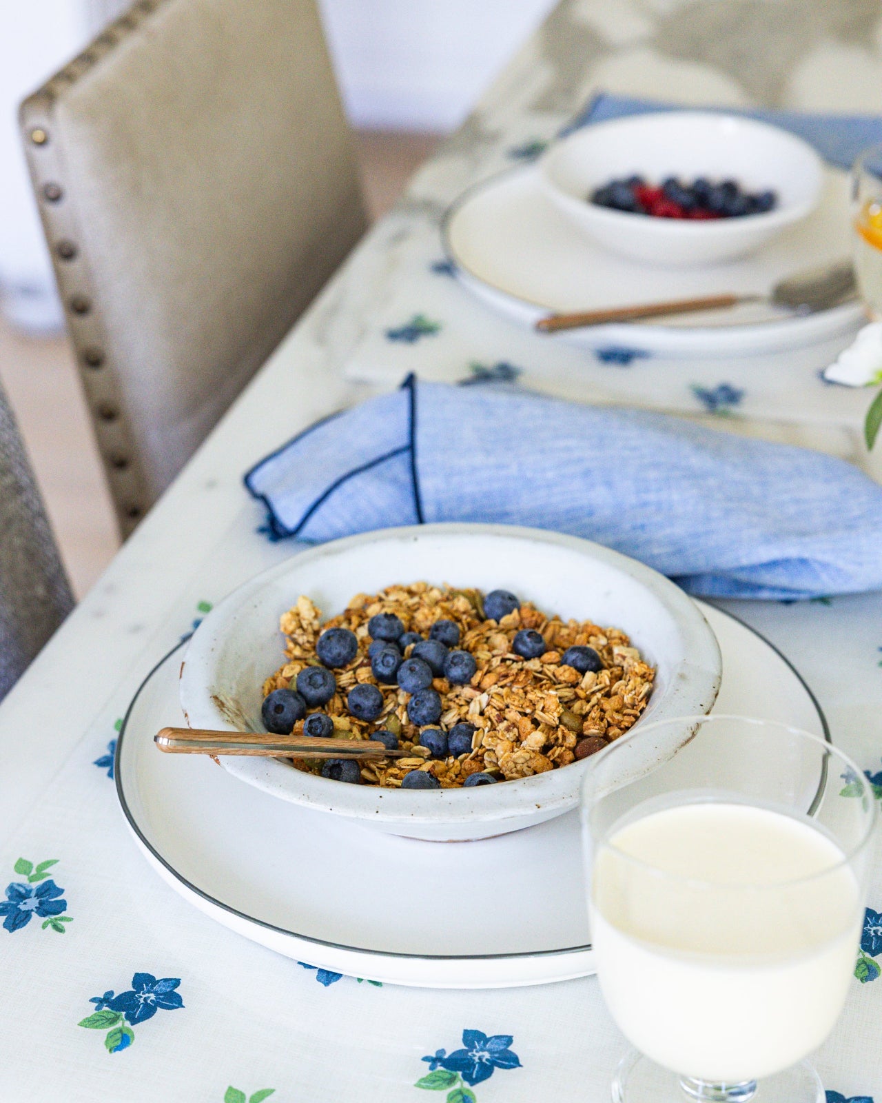
                  
                    Acrylic tablemats in white and blue with bowls of granola at marble counter with blue linen napkins.
                  
                