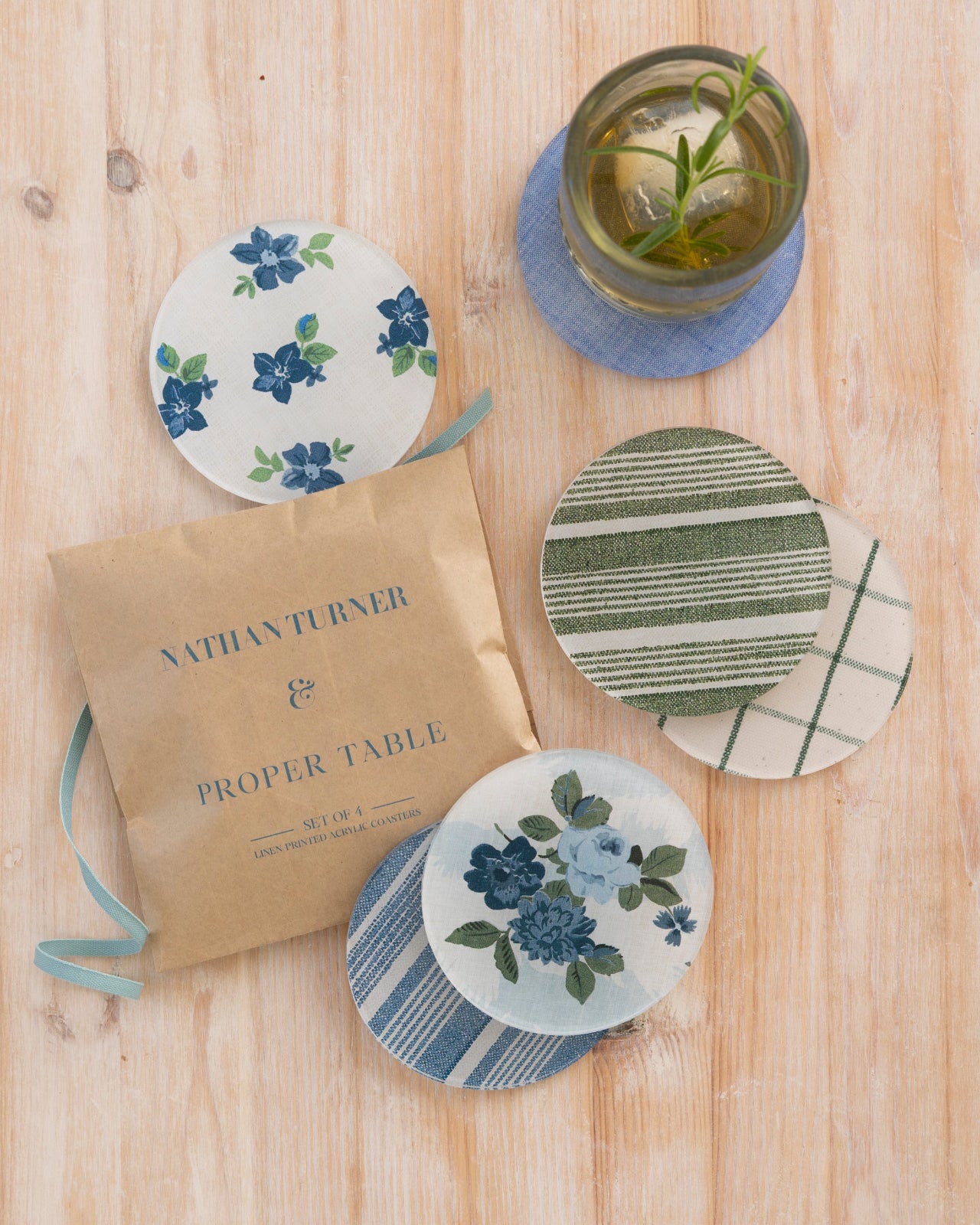 Set of floral and patterned coasters on a wooden surface from the Nathan Turner Interiors and Proper Table collaboration.