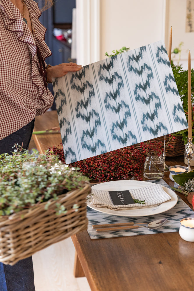 Proper Table Founder Dana Lewis styling a the Isla rectangular blue and white ikat acrylic placemat from Proper Table, setting a holiday table with Eliot ticking napkins and greenery. Setting a holiday table.
