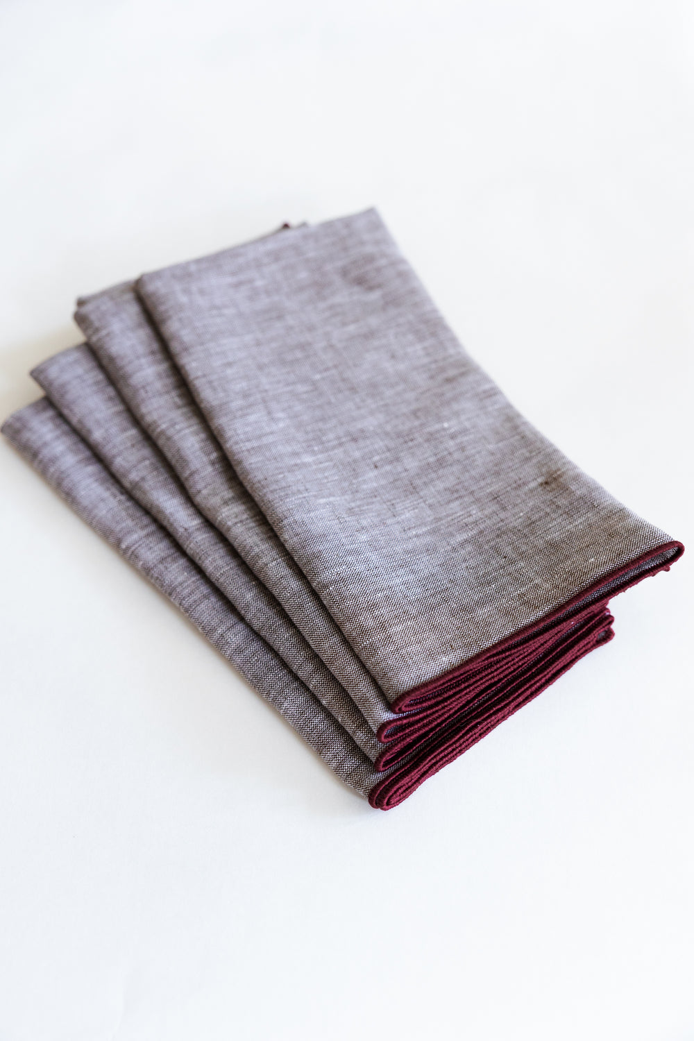 Warm brown linen napkins with burgundy trim. 
