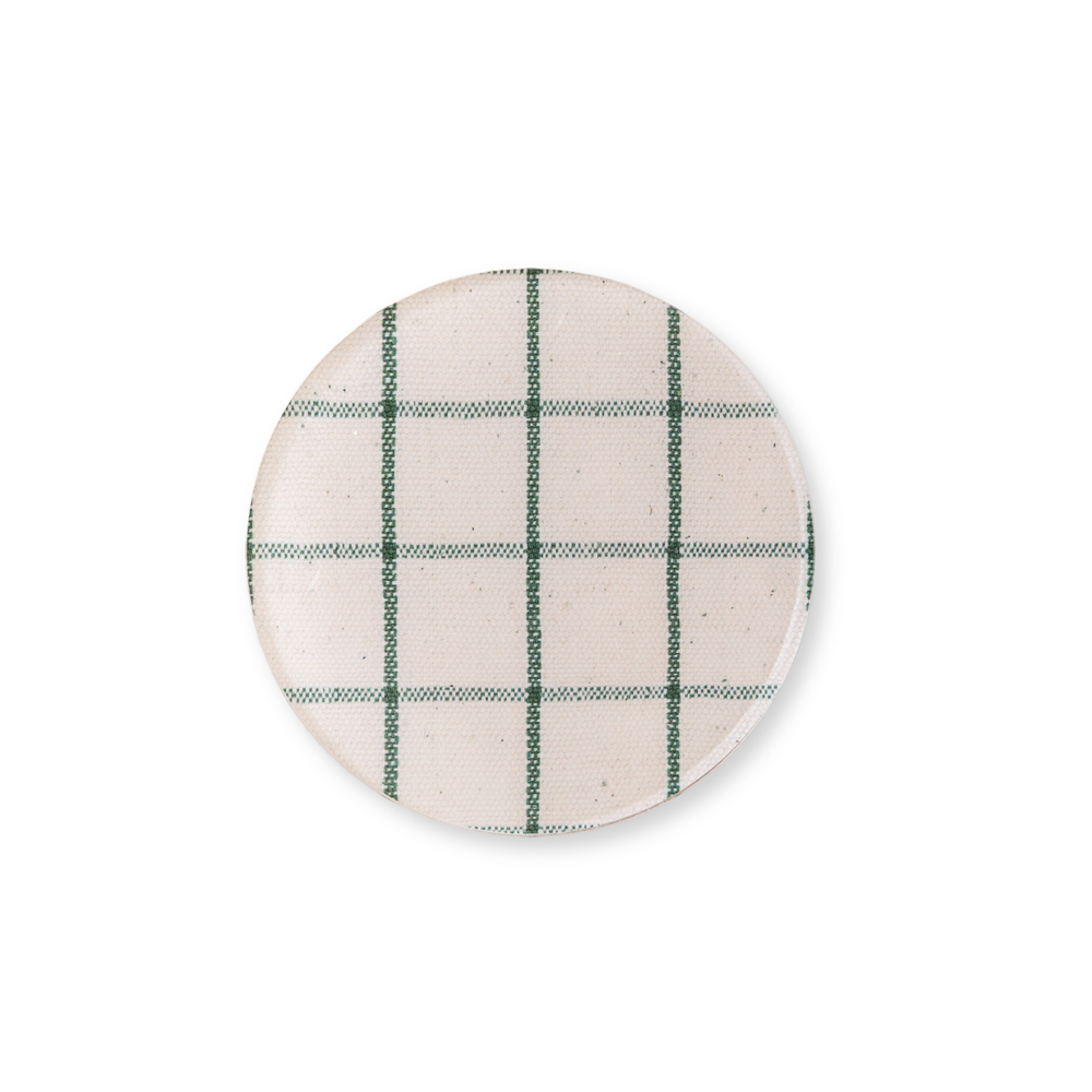 Round acrylic coaster with green check pattern on a white background.